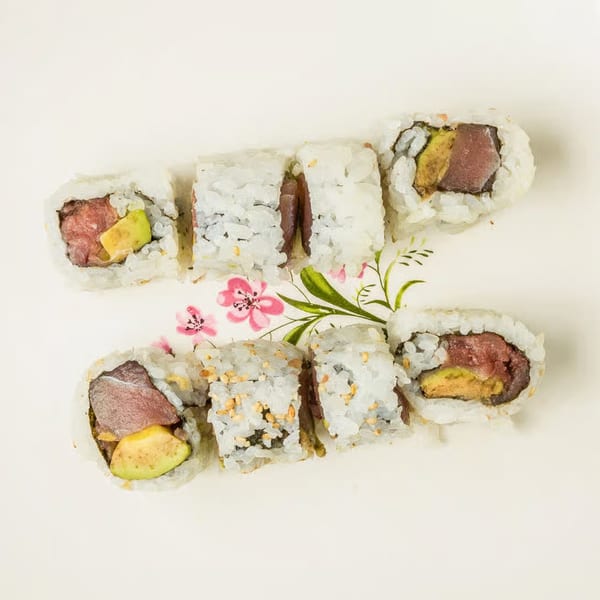 Kei Sushi Restaurant's tuna and avocado sushi rolls on a white plate with pink floral design.