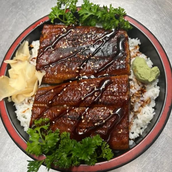Kei Sushi Restaurant's unagi donburi with grilled eel, rice, pickled ginger, wasabi, and parsley.